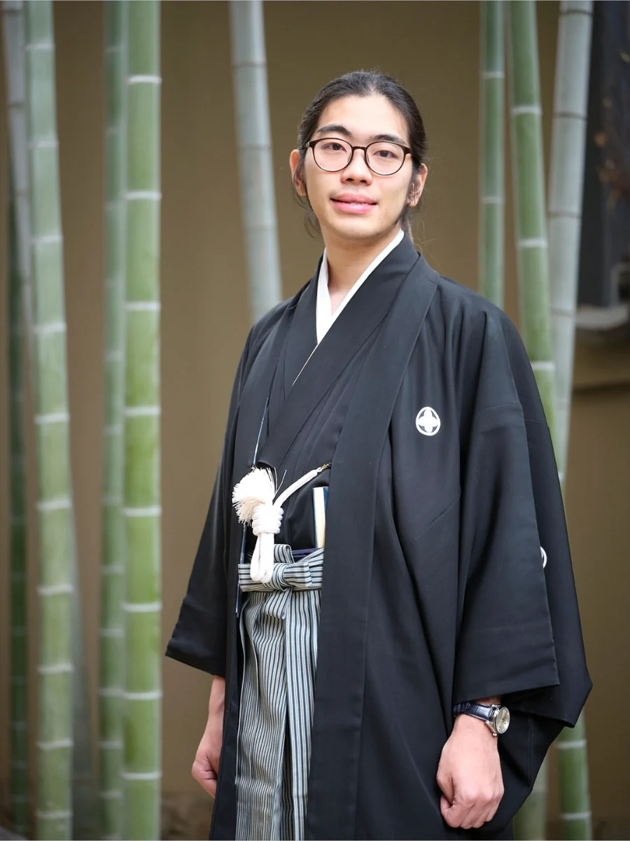 第6回カレッジ文化祭 委員長 森内貴之。竹林を背に、紋付袴姿で立っている。