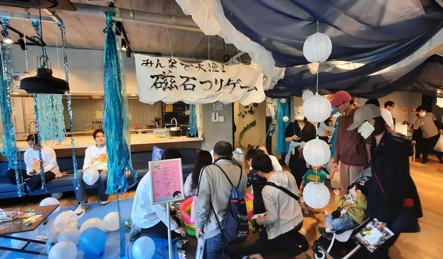 手作りの看板や海をイメージした装飾に囲まれた体験企画を、来場者が楽しんでいる。